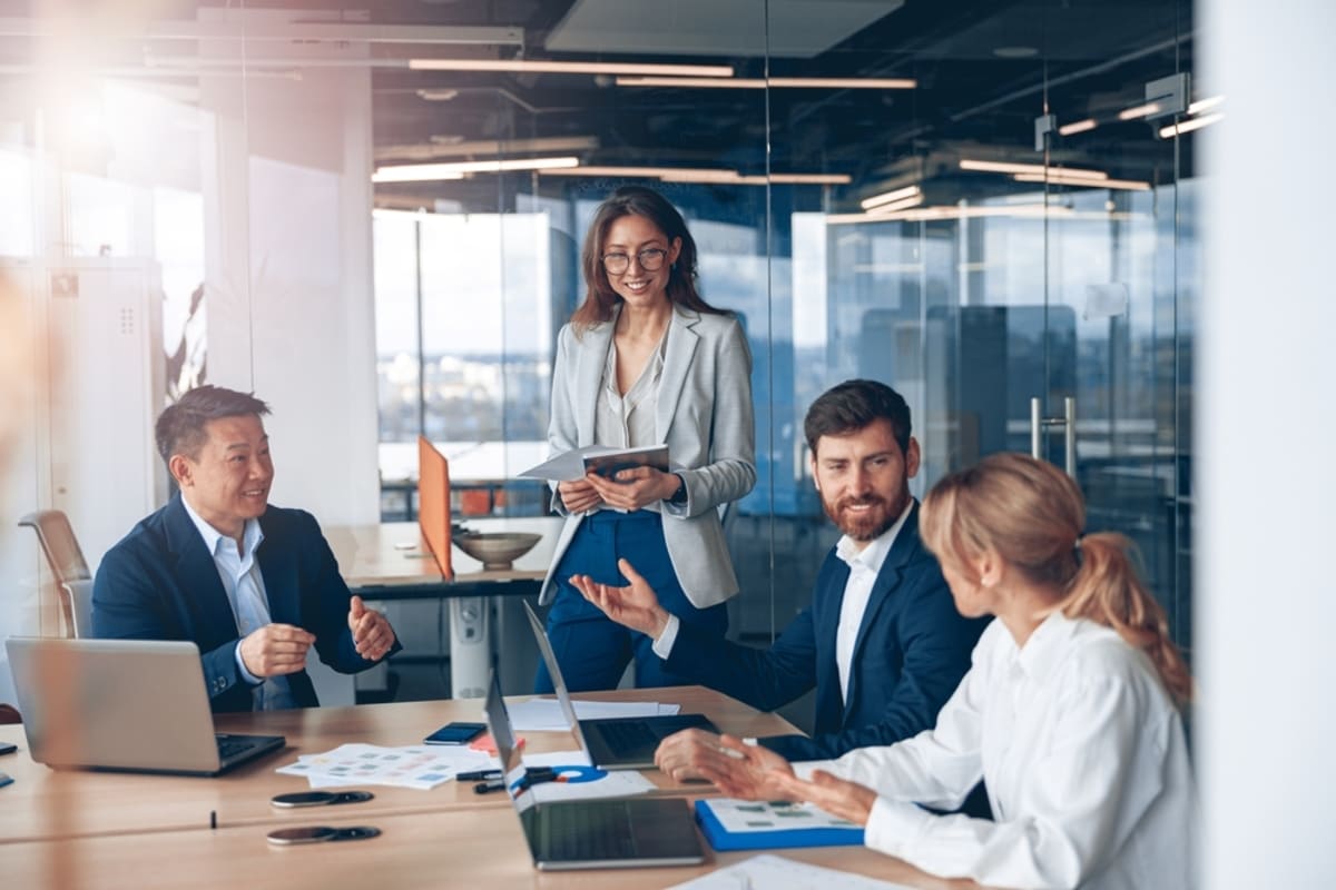 A group of smiling businesspeople having a meeting, commercial real estate broker services concept