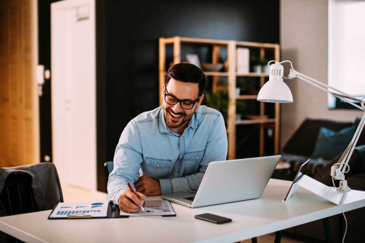 A man smiling at his desk - peace of mind when partnering with commercial properties management concept