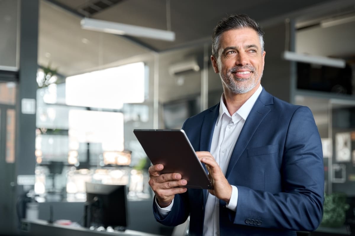 Smiling businessman with a tablet, success through Chicago commercial real estate investing concept